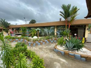 Un bâtiment avec une bande de plantes devant lui dans l'établissement Hotel Wilson Upala, à Upala