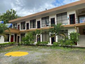 un condominio con balcone e palme di Hotel Wilson Upala a Upala