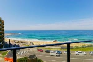 a view of a beach and the ocean from a balcony at Arena Newcastle Beach in Newcastle