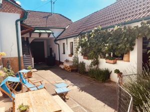 un patio al aire libre con sillas azules y una mesa en derHofRat en Litzelsdorf