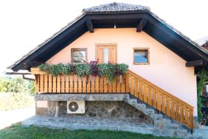 uma casa com uma varanda com flores em Apartma ''Pri Movernu'' em Semič