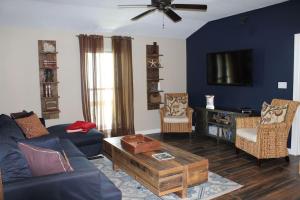 uma sala de estar com um sofá e cadeiras e uma televisão em Enjoy Our Ocean Oasis em Galveston