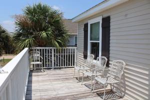 um deque com cadeiras e mesas numa casa em Enjoy Our Ocean Oasis em Galveston