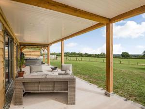 a covered patio with a couch and a table at Bramley Lodge - Uk38384 in Lyonshall
