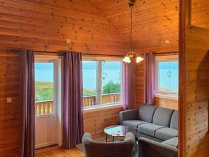 un soggiorno con un divano e due finestre di 6 person holiday home in Brekke a Brekke