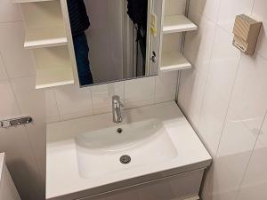 un lavandino bianco in un bagno con uno specchio di 6 person holiday home in Brekke a Brekke Altre 10 foto