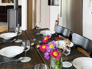 a wooden table with flowers and wine glasses on it at Four-Bedroom Holiday home in Jelsa 2 in Jelsa