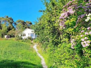 4 person holiday home in UDDEVALLA في Sundsandvik: منزل على جانب تل مع الزهور