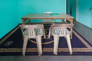 uma mesa e duas cadeiras num quarto em SPOT ON 91732 Rani Homestay Syariah em Jodoh