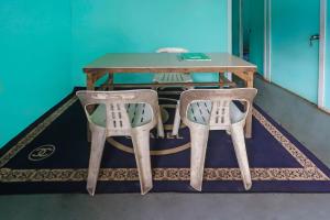 a table and two chairs in a room at Hotel O Rani Homestay Syariah in Jodoh