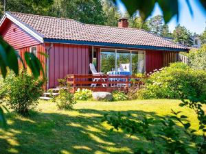 um barracão vermelho com uma mesa e uma cadeira num quintal em Holiday home Sandefjord II em Sandefjord