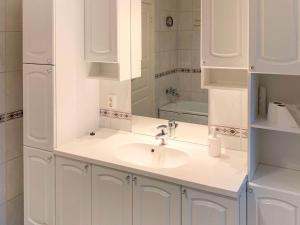 ein weißes Badezimmer mit einem Waschbecken und einem Spiegel in der Unterkunft Holiday home Brekke in Brekke