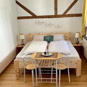 a bedroom with a bed with a table and chairs at derHofRat in Litzelsdorf