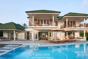 een villa met een zwembad en een huis bij Siyam World Maldives - 24-Hour Premium All-inclusive with Free Transfer in Dhigurah