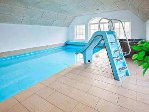 una piscina con un tobogán azul en una habitación en 18 person holiday home in Ulfborg, en Ulfborg