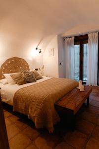 een slaapkamer met een groot bed en een houten tafel bij Casa Jaraíz - Centre town in Caravaca de la Cruz