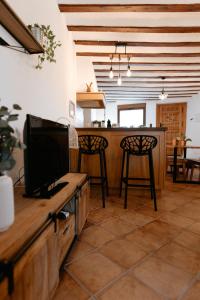 a living room with a television and a counter with chairs at Casa Jaraíz - Centre town in Caravaca de la Cruz