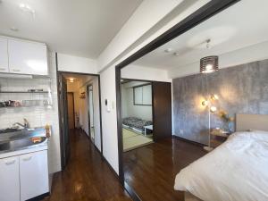 大阪MORI Apartment Dotonbori 2DK的一间带床和水槽的客房和一间厨房