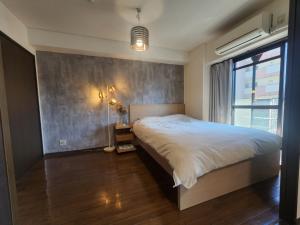 Un dormitorio con una cama grande y una ventana en MORI Apartment 道頓堀(Dotonbori) 2DK, en Osaka