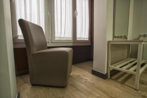 a chair sitting in a room next to a window at Hostal Elvira in Aranda de Duero