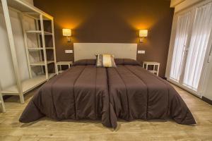 a bedroom with a bed and a dresser at Hostal Elvira in Aranda de Duero