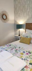 1 Schlafzimmer mit einem Bett mit Blumenbettdecke in der Unterkunft VILLA GARRIGA in Le Bois de Nèfles