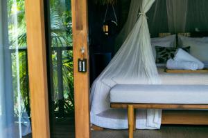 a bedroom with a bed with a mosquito net at ONAYA Bali Resort - Adults Only in Uluwatu