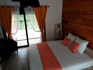 1 dormitorio con cama con almohadas y ventana en Auberge du dom en Bormes-les-Mimosas