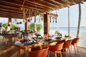 a dining room with a table and chairs and the ocean at Siyam World Maldives - 24-Hour Premium All-inclusive with Free Transfer in Dhigurah