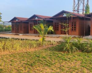 a house is shown with a field in front of it at Nirvana Resort and Restaurant in Garudeshwar