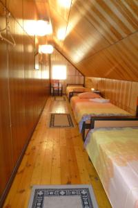 Kihelkonna Pastorate Guesthouse في Kihelkonna: غرفة بثلاث اسرة وارضية خشبية