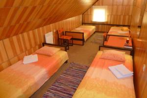Kihelkonna Pastorate Guesthouse في Kihelkonna: غرفة صغيرة بها ثلاثة أسرة ومكتب