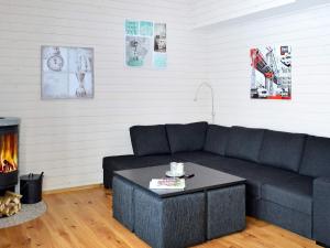 a living room with a black couch and a fireplace at 10 person holiday home in S LEN in Stöten