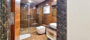 a bathroom with a shower and a toilet and a sink at ROYAL CLIFF HOTEL & RESORTS in Nagpur