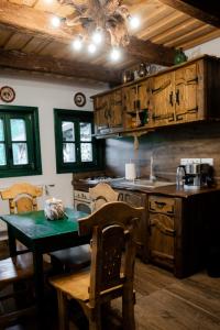 una cocina con armarios de madera y una mesa con sillas. en Huta Village, en Piatra