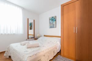 a bedroom with a bed and a large wooden cabinet at Kristi apartment complex near the sandy beach - by TA Leut Agency in Privlaka