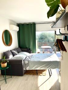 1 dormitorio con 1 cama y cortina verde en loumax, en Gassin