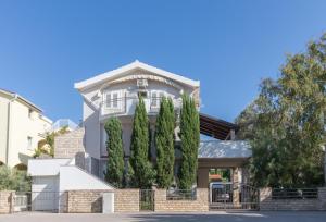 a house with trees in front of it at Kristi apartment complex near the sandy beach - by TA Leut Agency in Privlaka