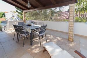 a patio with a table and chairs and a fence at Kristi apartment complex near the sandy beach - by TA Leut Agency in Privlaka