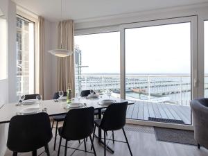 a dining room with a table and chairs and a large window at Apartment Wendtorf XVI in Wendtorf