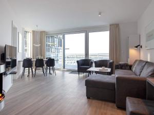 a living room with a couch and a table with chairs at Apartment Wendtorf XVI in Wendtorf