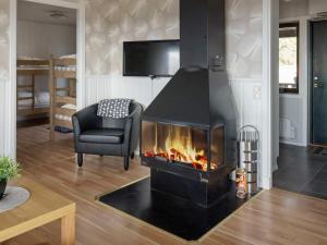 - un salon avec une cheminée et une chaise dans l'établissement 6 person holiday home in KOPPARBERG, à Kopparberg