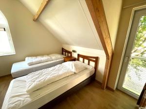 twee bedden in een kamer met een zolder bij Vakantiewoning Banjaard in Kamperland
