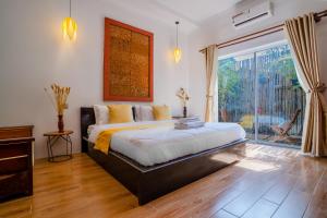 a bedroom with a large bed and a large window at Angkor Rithy Boutique in Siem Reap