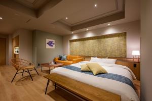 a bedroom with a large bed and a couch at BAMBOO GARDEN 相模原 in Sagamihara