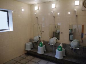 a bathroom with four urinals in a room at Kongo Sanmaiin in Koyasan