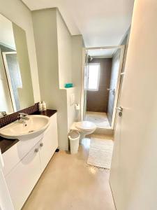 a white bathroom with a sink and a toilet at 706 Portico in Cape Town