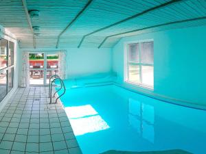 une piscine dans une pièce aux murs bleus dans l'établissement 12 person holiday home in Nordborg, à Nordborg