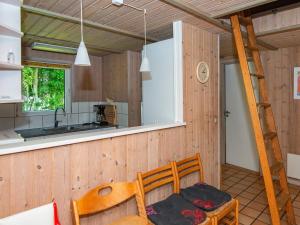 - une cuisine avec des murs en bois, une table et une échelle dans l'établissement 12 person holiday home in Nordborg, à Nordborg