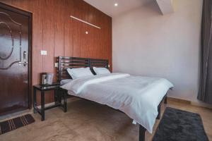 - une chambre avec un lit et un mur en bois dans l'établissement Spandan Villas, à Dhanaulti
